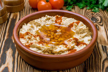 Traditional homemade hummus on wooden table. Turkish cuisine.