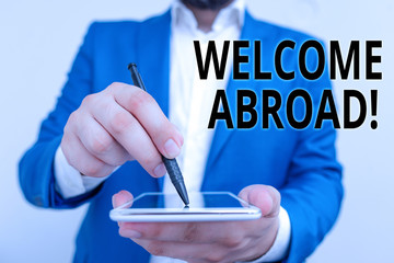 Conceptual hand writing showing Welcome Abroad. Concept meaning something that you say when someone gets on ship Businessman in blue suite with laptop pointing with finger