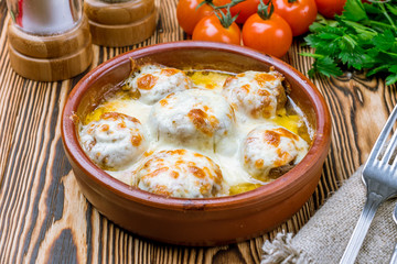 mushrooms baked with Suluguni cheese on wooden table