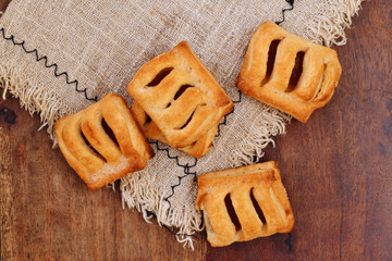 Puff pastry filled with appicot jam on a wooden table