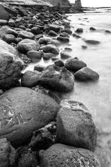 ROCKS ON THE SHORE AND SEA WATER. BLACK AND WHITE PHOTOGRAPHY