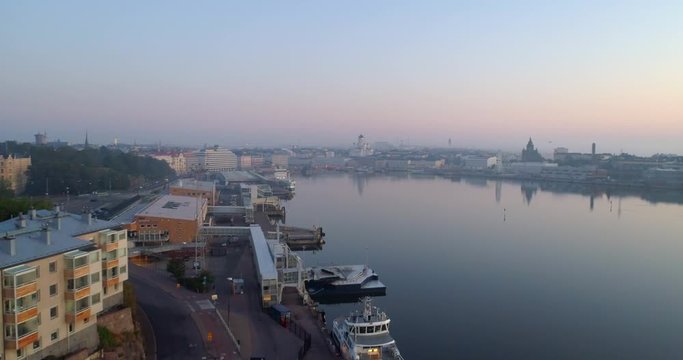 Helsinki south harbor, Aerial, rising, drone shot overlooking the cityscape, purple sky, on a sunny and foggy autumn day, in Helsingfors, Uusimaa, Finland
