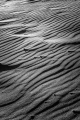 TEXTURE AND FORMS OF BEACH SAND. BLACK AND WHITE PHOTOGRAPHY