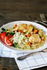 Chicken with Cauliflower Rice. low carbohydrates a lot of protein. stewed chicken with celery and carrots in a white plate. keto dish. 