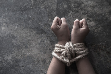 Hands tied up with rope of a missing kidnapped, abused, Violence against children, victim child in pain, human trafficking Concept.