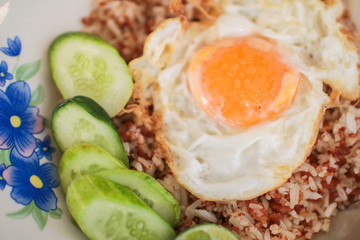 Stir fried rice, minced pork and basil topped with fried egg. Thai famous food.Macro shot of delicious Asian vegetable rice cuisine