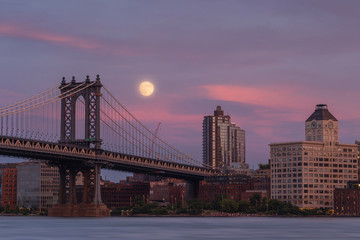 Manhattan bridge from east river at sunset with full moon rise,long exposure