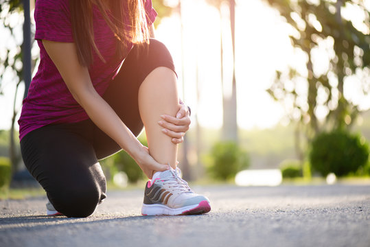 Ankle sprained. Young woman suffering from an ankle injury while exercising and running. Healthcare and sport concept.