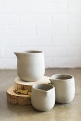Three concrete milk containers on wooden slices, white background