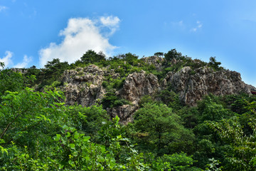 Peaks and forest landscape in the background of blue sky and white clouds. Photographed in Dagushan, Dandong, Liaoning, China - obrazy, fototapety, plakaty