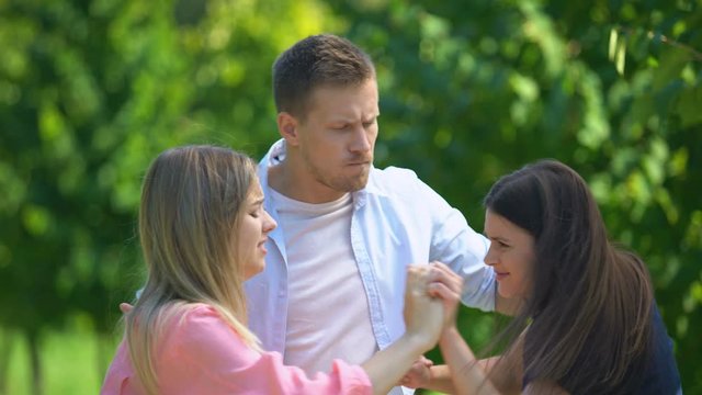 Brunette and blonde girls fighting for attention and love of man, relationships