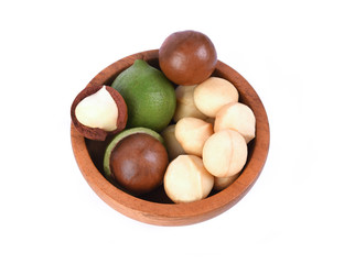 Macadamia nuts in wooden bowl on white background top view