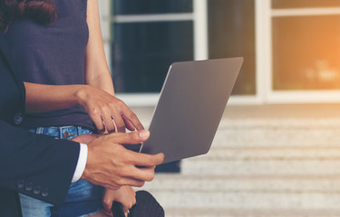 business man and business woman are working in notebooks on the ladder