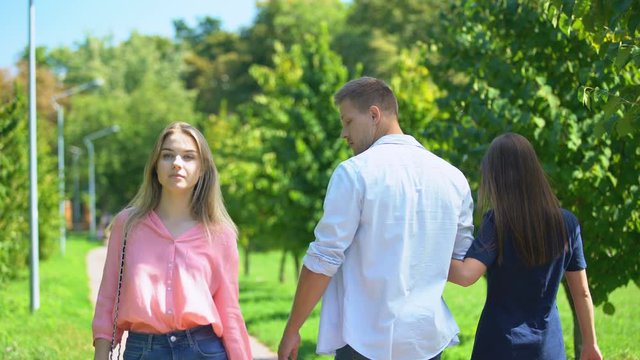 Guy staring at passing blonde walking along park with his girlfriend, lovelace