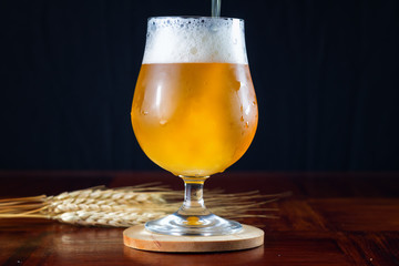 Hazy IPA craft beer being poured into a tulip shaped beer glass.