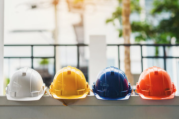 White, yellow and other colored safety helmets for workers' safety projects in the position of...
