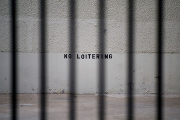 no loitering sign behind black bars