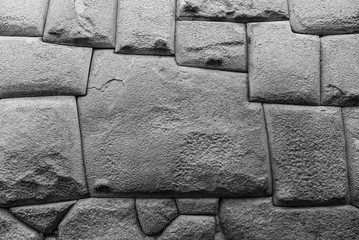 Black and white photograph of the famous twelve angle stone in the Hatun Rumiyoc street, Cusco, Peru. This perfect stonework can be found in other Inca sites as Machu Picchu, Sacsayhuaman, Pisac... - obrazy, fototapety, plakaty
