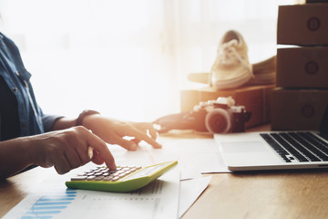 Women hand doing finances and calculate on desk about cost at home office, Online selling...