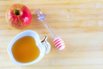 Jewish holiday Rosh Hashana background with honey and apple on wooden table. During the Jewish New Year Rosh Hashanah customary eat sliced apples dipped in honey symbol sweet new year.