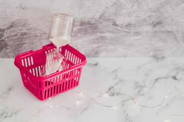 Fototapeta na wymiar pink shopping basket with hourglass concept of flash sales