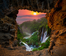 Waterfall in the Plitvice Lakes National Park seen from a natural rock cave