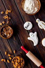 Cooking creepy cookies concept with almonds, pin, flour on wooden background top view