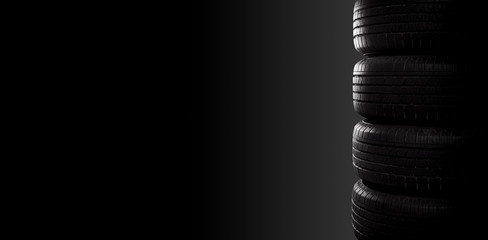 Studio shot of four black car tires on black background with copy space. © happy_author
