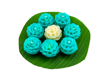 Traditional Thai dessert flower shape stuff with crush soybean and taro (Thai name kanom Chor phaka)  on green banana leaf isolated on white background.Saved with clipping path.