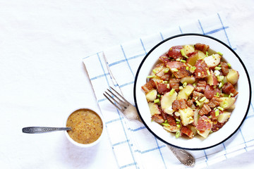 German potato salad with fried bacon and mustard dressing. traditional for oktoberfest festival. top view. copy space.