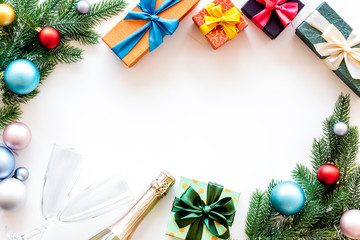 Presents for christmas in boxes, champagne and spruce frame on white background top veiw copyspace