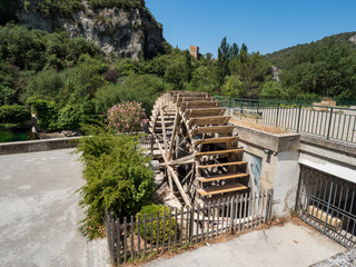 France, july 2019: Old paper-mill and wooden water wheel to power the mill in Fontaine de Vancluse, Provence