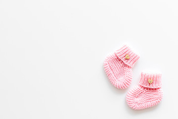 Knitted pink footwear for baby on white background top view mockup