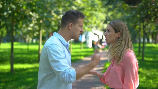 Couple emotionally arguing outdoors, misunderstanding in family, conflict
