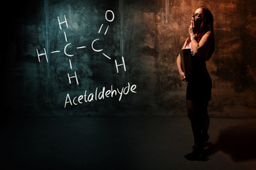 Sexy girl or secretary or female student presenting handdrawn chemical formula of acetaldehyde