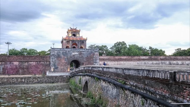 Day to Night time lapse of citadel entrance in the ancient city of Hue, Vietnam. Traffic streams over the bridge. As night falls the image is taken over by the beautiful colors of the artificial light
