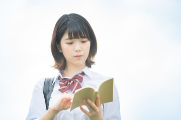 Obraz premium 屋外で読書する女子高生