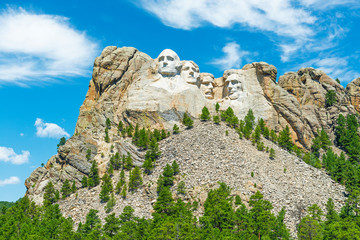The carved faces of US presidents in Mount Rushmore national monument and the pine tree forest in the Black Hills, Rapid City, South Dakota, United States of America, USA.