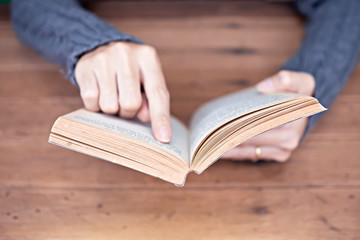 Hand holding a book at home