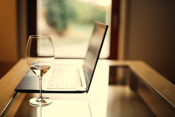 Desk Laptop with wineglass, home office, work in the evenings