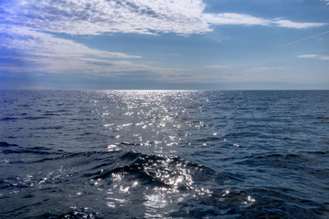 Fototapeta na wymiar Mer à perte de vue avec les reflets du soleil au lever du jour - navigation en pleine mer