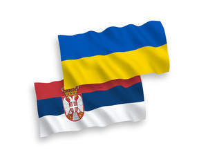 National vector fabric wave flags of Serbia and Ukraine isolated on white background. 1 to 2 proportion.