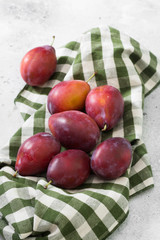 Red plums on the grey table
