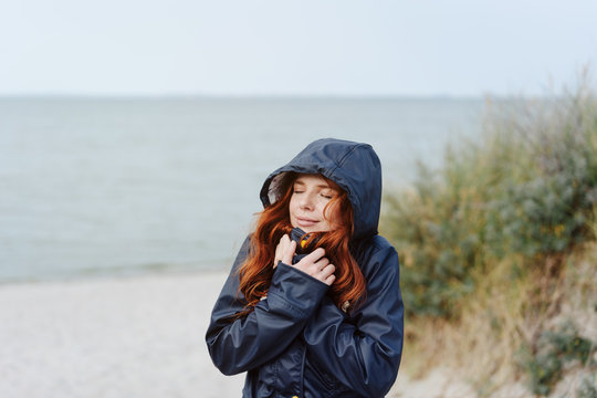 Young Woman Snuggling Into A Warm Anorak