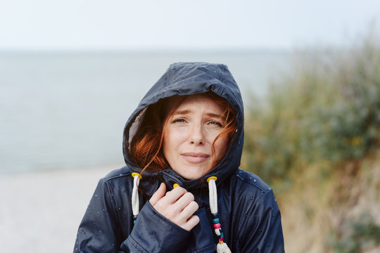 Freezing cold woman snuggling into her anorak