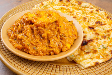 Indian Vegetarian Cuisine Special Sweet And Spicy Paneer Pasanda or Stuffed Paneer Curry, Delicacy Consisting of Stuffed Paneer with Rich Creamy Gravy Served With Garlic Naan on Vintage Background