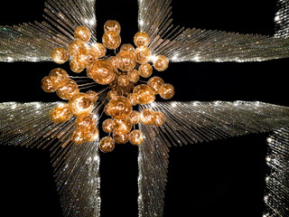 Crystal chandelier with dark background, bottom view.