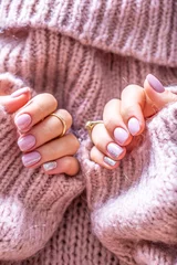 Gordijnen Art nail manicure for bride in purple sweater. Gel nails in soft pink color © weyo