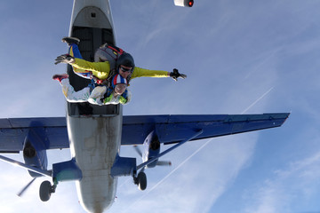 Fototapeta na wymiar Skydiving. A tandem is in the sky. An young girl and her instructor.