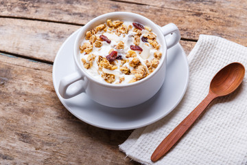 Muesli with yoghurt in white bowl. Healthy fitness breakfast background
